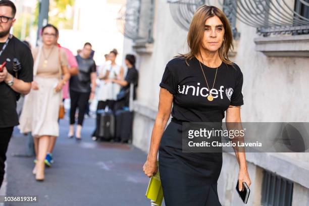Carine Roitfeld, wearing a Unicef black t shirt and skirt, is seen in the streets of Milano before the Prada show during Milan Fashion Week...