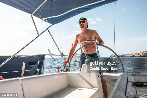 young man sailing a boat - captain yacht stock pictures, royalty-free photos & images