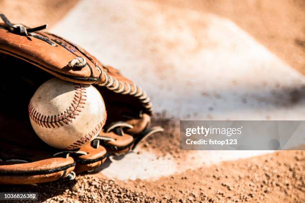 temporada de béisbol está aquí.  guante y pelota en el plato de home. - glove fotografías e imágenes de stock