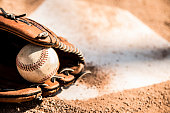 Baseball season is here.  Glove and ball on home plate.