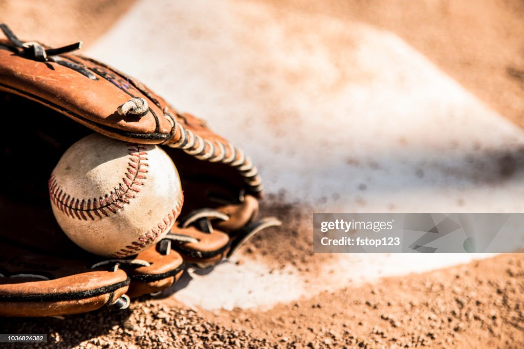 Baseball season is here.  Glove and ball on home plate.