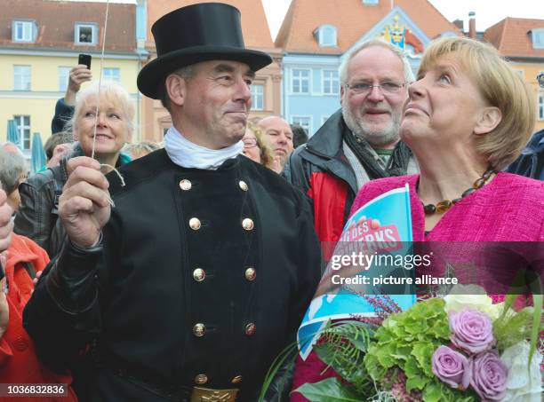 Chancellor Angela Merkel of the Christian Democratic Union appreciates best wishes from a chimney sweep at the final of her campaign in Stralsund,...