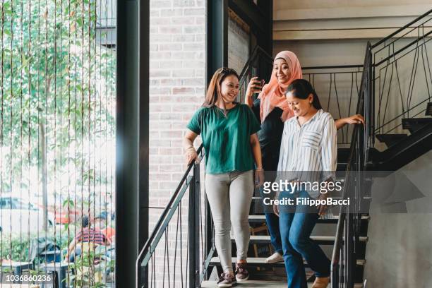 three women taking a coffee break together - muslim women group stock pictures, royalty-free photos & images
