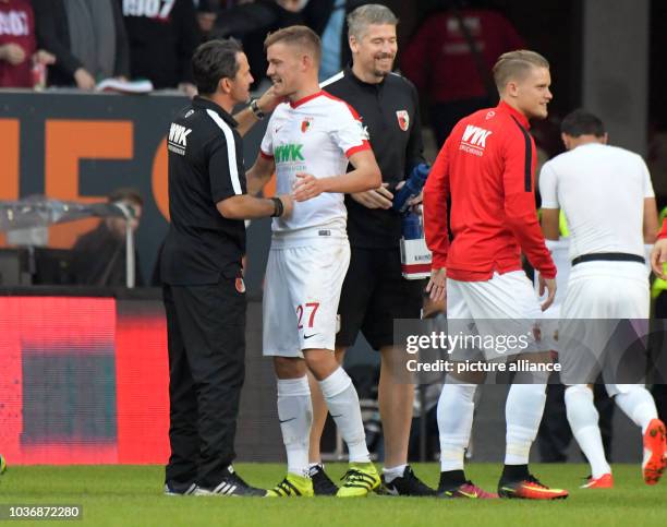 Coach of Augsburg, Dirk Schuster, congratulates goalscorer Alfred Finnbogason of Augsburg, whose team won 1:0 in the match of FC Augsburg against...