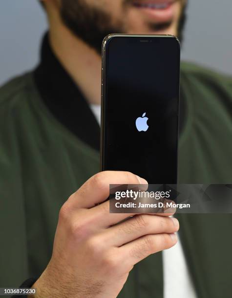 Customer handles their new iPhone at the Australian release of the latest iPhone models at the Apple Store on September 21, 2018 in Sydney,...