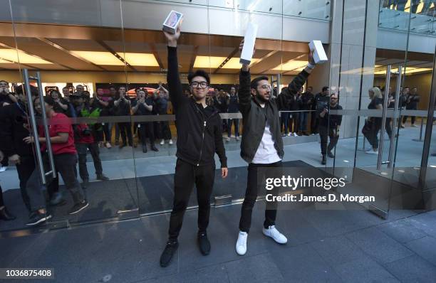 Two customers celebrate their new purchase at the Australian release of the latest iPhone models at the Apple Store on September 21, 2018 in Sydney,...