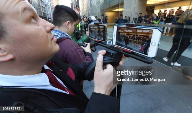 Journalist uses two iPhones to record footage at the Australian release of the latest iPhone models at the Apple Store on September 21, 2018 in...