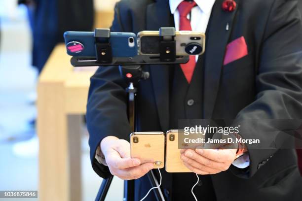 Journalist uses two iPhones to film two of the new iPhones at the Australian release of the latest iPhone models at the Apple Store on September 21,...