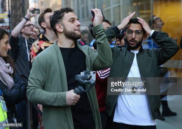 Mazen Kourouche fixes his hair as he waits at the front of the line during the Australian release of the latest iPhone models at Apple Store on...