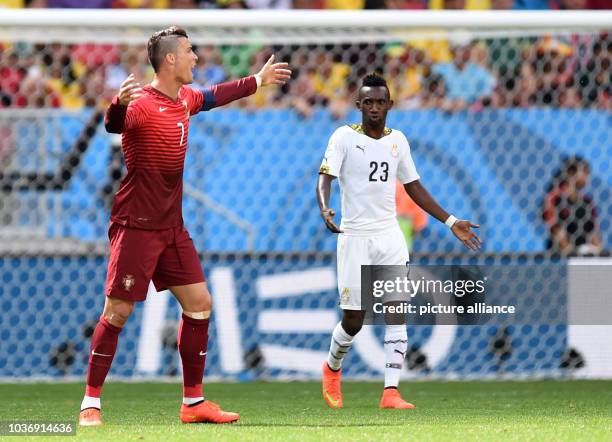 Cristiano Ronaldo of Portugal reacts next to Harrison Afful of Ghana during the FIFA World Cup 2014 group G preliminary round match between Portugal...