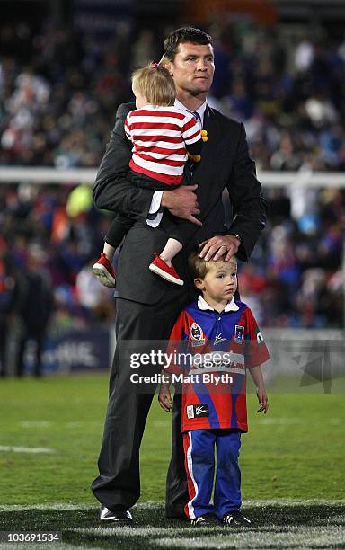 Steve Simpson of the Knights watches the big screen with his children before the round 25 NRL match between the Newcastle Knights and the St George...