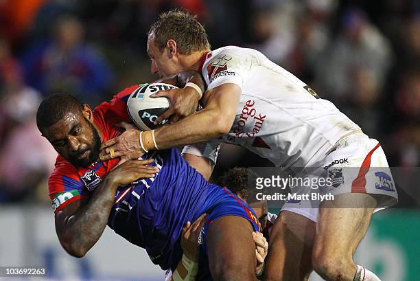 Wes Naiqama of the Knights is tackled during the round 25 NRL match between the Newcastle Knights and the St George Illawarra Dragons at...