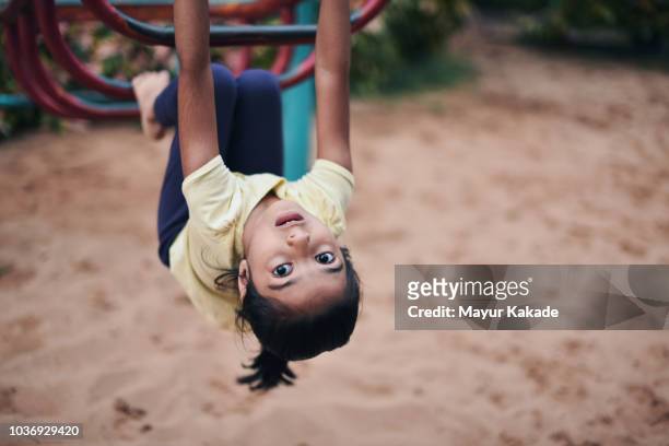 Young girl (4-5 years) hanging on the ladder at children’s play area