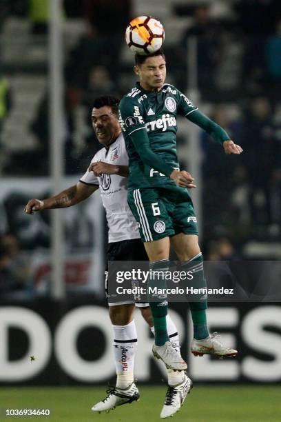 Esteban Paredes of Colo Colo goes for a header against Diogo Barbosa during a quarter final first leg match between Colo Colo and Palmeiras as part...