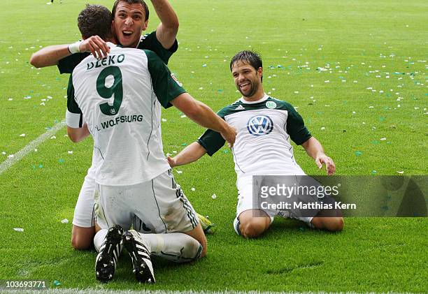 Edin Dzeko of Wolfsburg jubilates with Mario Mandzukic and Diego Ribas da Cunha after scoring the first goal during the Bundesliga match between VFL...