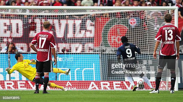 Papisse Cisse of Freiburg scores a penalty shot asgainst goalkeeper Raphael Schaefer of Nuernberg as Nuernberg's Mike Frantz and Jens Hegeler watch...