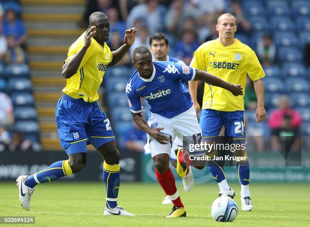 John Utaka of Portsmouth battles with Seyi Olifinjana of Cardiff City during the npower Championship match between Portsmouth and Cardiff City at...