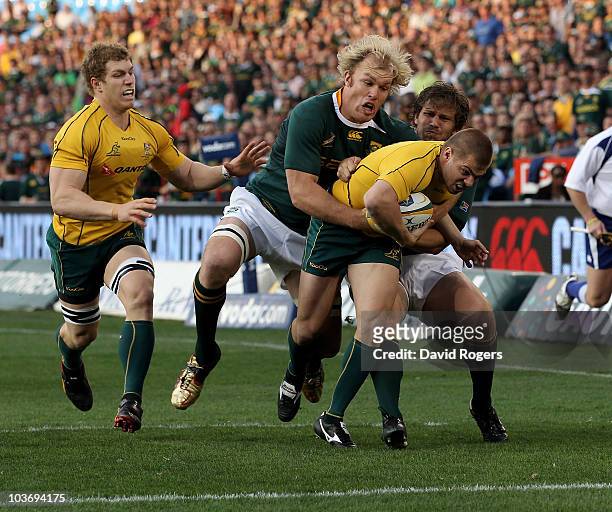 Drew Mitchell of Australia is tackled short of the tryline by Schalk Burger and Frans Steyn during the 2010 Tri-Nations match between the South...