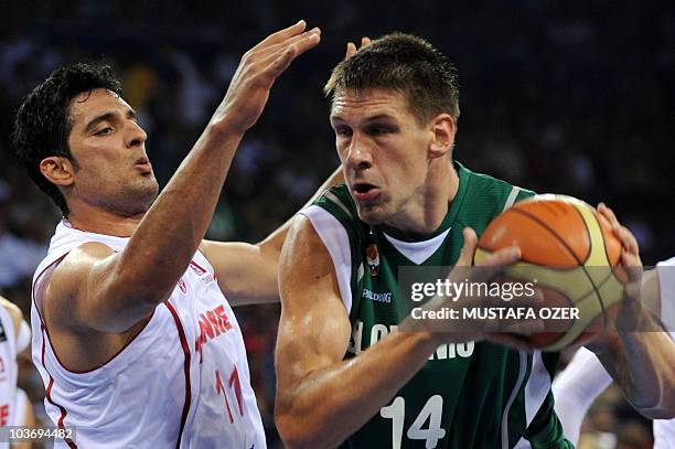 Gasper Vidmar of Slovenia keeps the ball from Mohamed Ghyaza of Tunusia during the preliminary round group B match between Slovenia and Tunisia, at...