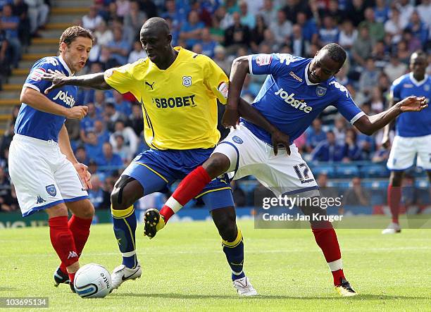 Seyi Olifinjana of Cardiff City holds off Michael Brown and John Utaka of Portsmouth during the npower Championship match between Portsmouth and...