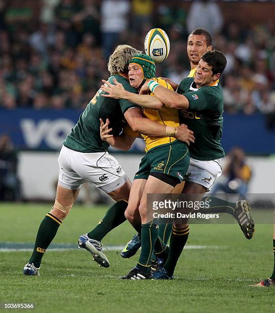 Matt Giteau of the Wallabies is tackled by Jean de Villiers and Morne Steyn during the 2010 Tri-Nations match between the South African Springboks...