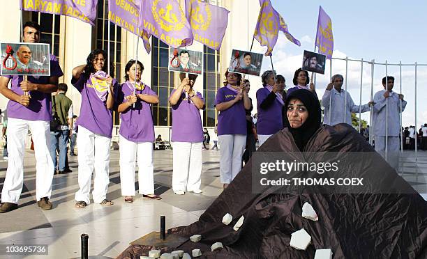 People take part in a demonstration on August 28, 2010 in front of the Eiffel tower at the Trocadero esplanade in Paris, in support to Sakineh...