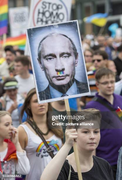 Demonstrators walk down Kurfuerstendamm and protest against Russia's new anti-gay propaganda law with a poster picturing Russian President Putin with...