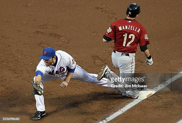Tommy Manzella of the Houston Astros is safe at first base ahead of the force from Ike Davis of the New York Mets allowing a run to score from third...