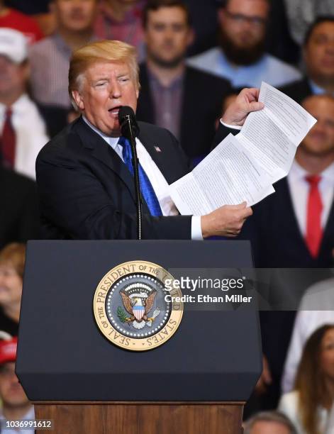 President Donald Trump reads from what he said was a list of his administation's accomplishments during a campaign rally at the Las Vegas Convention...