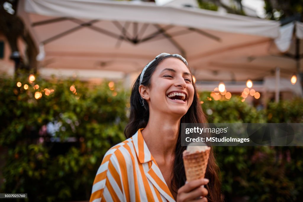 Smiling woman holding icecream.