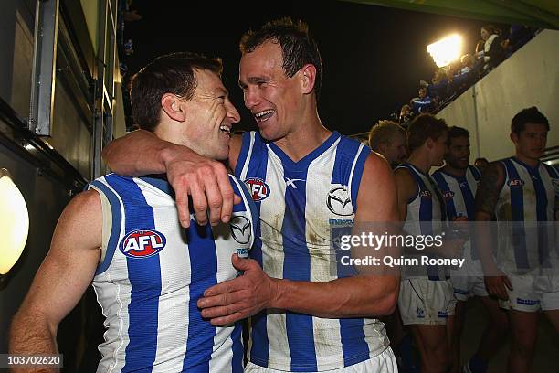 Brent Harvey and Corey Jones of the Kangaroos celebrate as they walk off the ground after winning the round 22 AFL match between the Melbourne Demons...