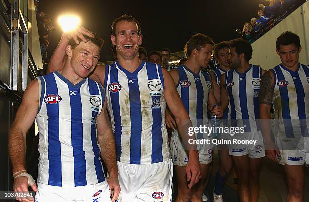 Brent Harvey and Corey Jones of the Kangaroos celebrate as they walk off the ground after winning the round 22 AFL match between the Melbourne Demons...