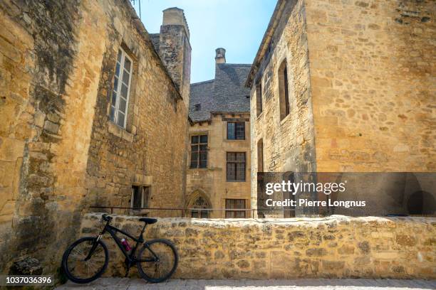 bicycle parked in upper part of a narrow street - périgord photos et images de collection