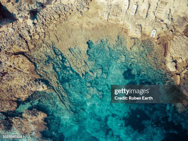 aerial view of a woman floating in the mediterranean coast - aerial view photos fotografías e imágenes de stock