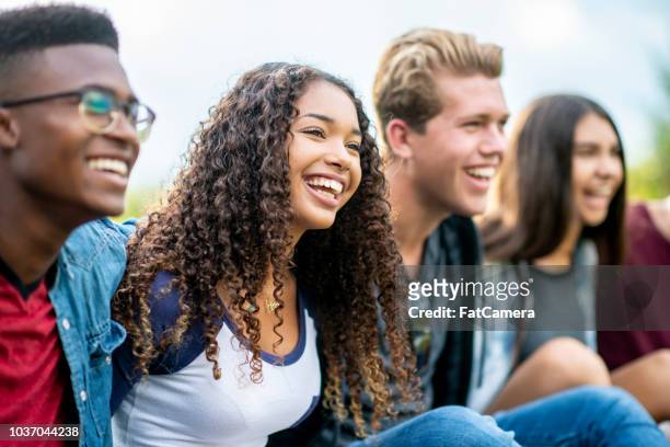 teenage friends laughing outside - young adult imagens e fotografias de stock