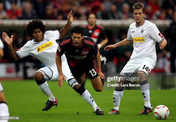 Michael Ballack of Leverkusen is challenged by Dante and Thorben Marx of Moenchengladbach during the Bundesliga match between Bayer Leverkusen and...