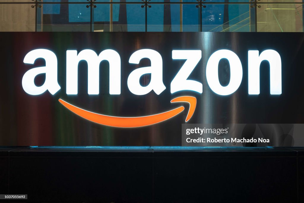 The Amazon logo illuminated at night.  The sign can be seen...