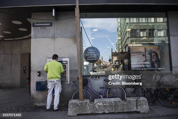 Customer uses an automated teller machine outside a Danske Bank A/S bank branch in Copenhagen, Denmark, on Wednesday, Sept. 19, 2018. Danske Bank...