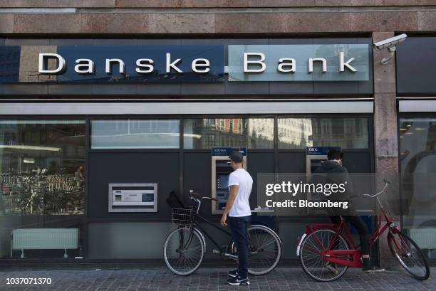 Customers on bicycles use automated teller machines outside a Danske Bank A/S bank branch in Copenhagen, Denmark, on Wednesday, Sept. 19, 2018....