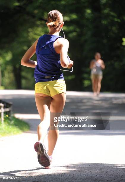 Eine Frau joggt am in München im Englischen Garten. Die Woche beginnt in Bayern mit sommerlichen Temperaturen. Foto: Tobias Hase/dpa