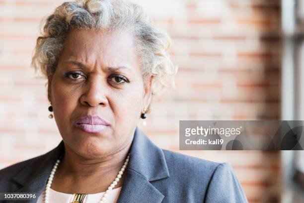face of serious mature african-american woman - angry black woman stock pictures, royalty-free photos & images