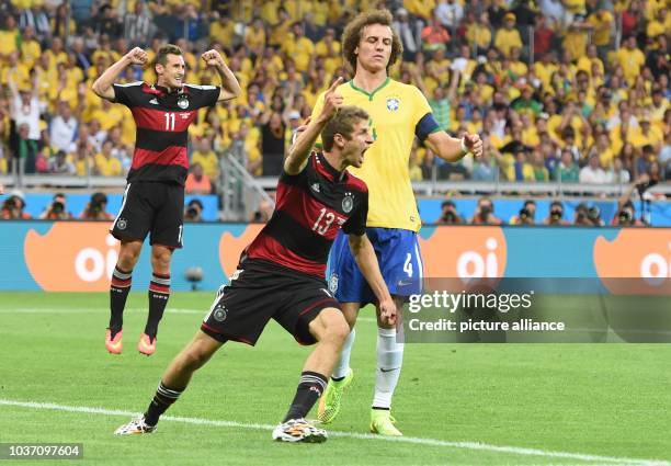 Germany's Thomas Mueller celebrates after scoring the 0-1 next to Brazil's David Luiz during during the FIFA World Cup 2014 semi-final soccer match...