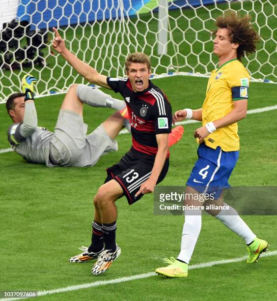 Germany's Thomas Mueller celebrates his 0-1 opening lead goal next to goalkeeper Julio Cesar and David Luiz of Brazil during the FIFA World Cup 2014...