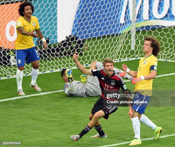 Germany's Thomas Mueller gestures after scoring the 0-1 next to Brazil's David Luiz Marcelo and goal keeper Julio Cesar during the FIFA World Cup...