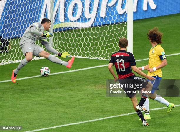 Germany's Thomas Mueller scores the 0-1 goal next to Brazil's David Luiz and goalkeeper Julio Cesar during the FIFA World Cup 2014 semi-final soccer...