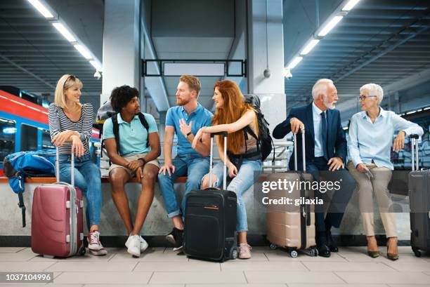 warten auf einen zug. - flughafen menschen stock-fotos und bilder