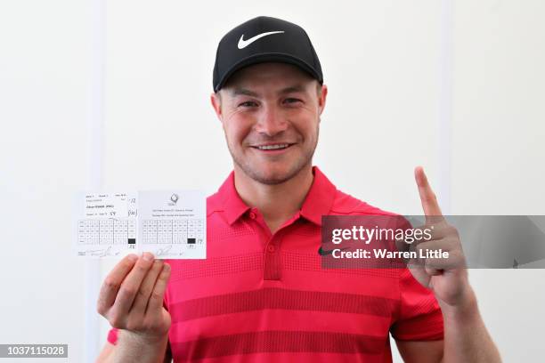 Oliver Fisher of England celebrates with his scorecard after finishing with a round of 59, the first 59 scored on the European Tour during Day Two of...