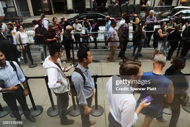 People wait in line to purchase the new iPhone XS and XS Max at the Apple store in Midtown Manhattan on September 21, 2018 in New York City. The two...