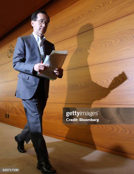 Masaaki Shirakawa, governor of the Bank of Japan, leaves a news conference after an emergency board meeting at the central bank's headquarters in...