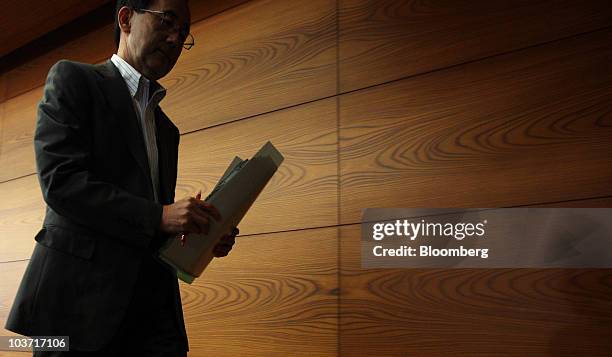 Masaaki Shirakawa, governor of the Bank of Japan, leaves a news conference after an emergency board meeting at the central bank's headquarters in...